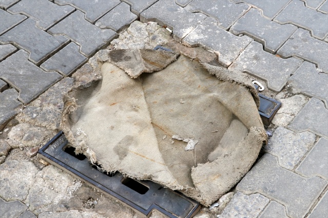 İzmir'de kanalizasyondan gelen koku nedeniyle mazgalların üzerine halı ve kilim örttüler