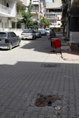 İzmir'de kanalizasyondan gelen koku nedeniyle mazgalların üzerine halı ve kilim örttüler