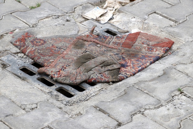 İzmir'de kanalizasyondan gelen koku nedeniyle mazgalların üzerine halı ve kilim örttüler