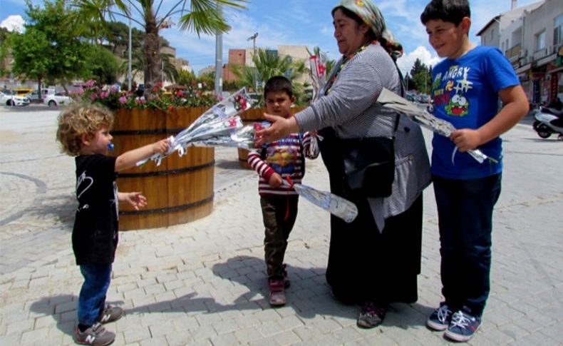 Ağzında emziği ile annelere karanfil verdi